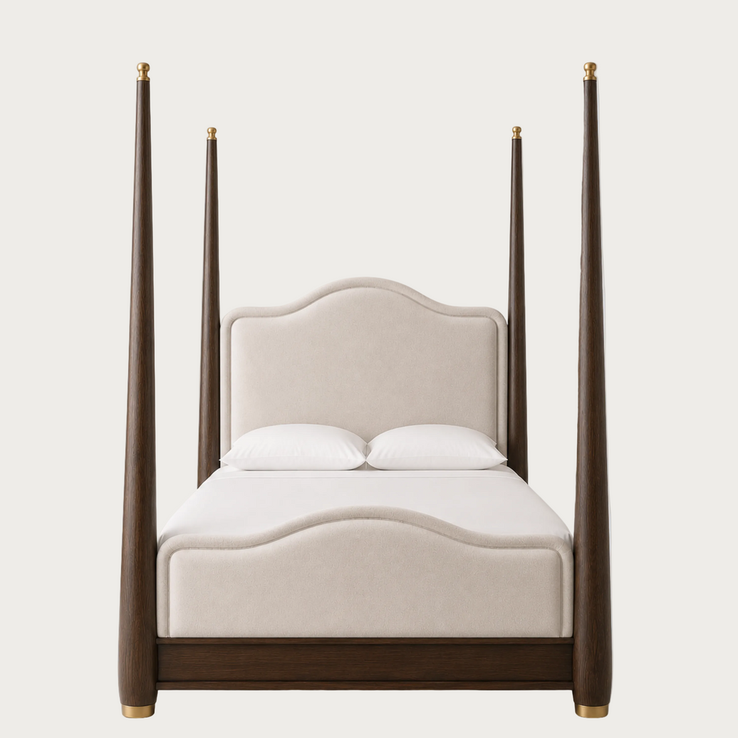 A modern four-poster bed featuring a dark brown wood frame with gold-toned metal caps on the posts and footboard, paired with a cream upholstered headboard and white bedding, shown against a solid light gray background.