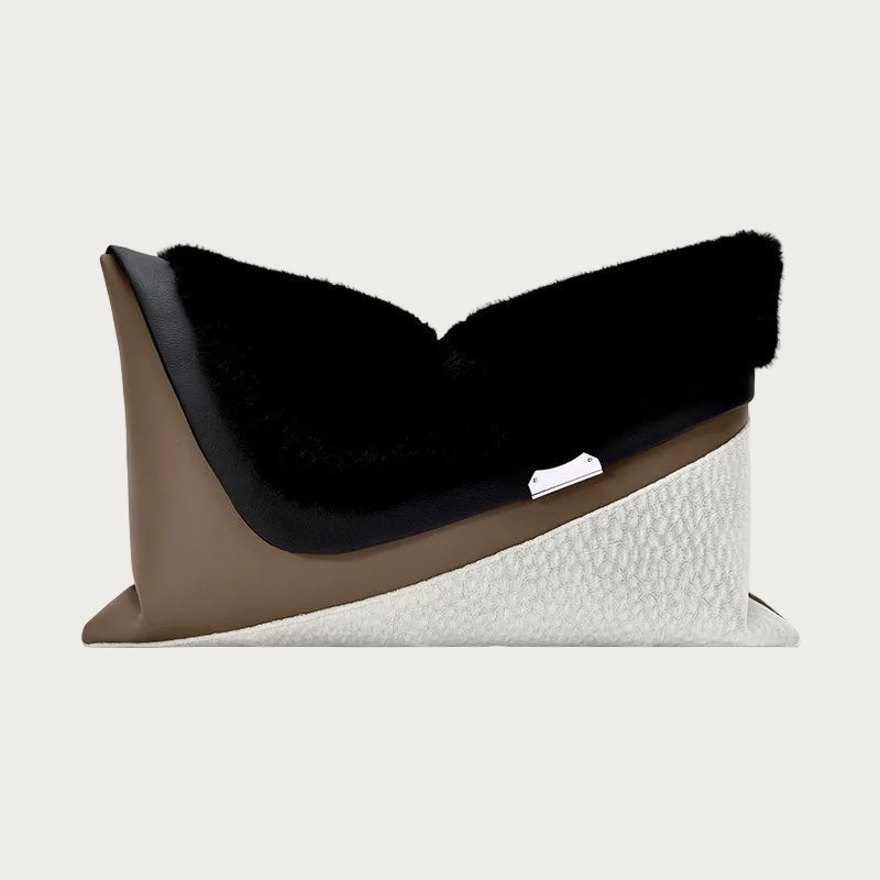A modern, sculptural throw pillow with a black faux-fur top, a smooth taupe-brown side panel, and a textured off-white bottom section, shown on a plain white background.