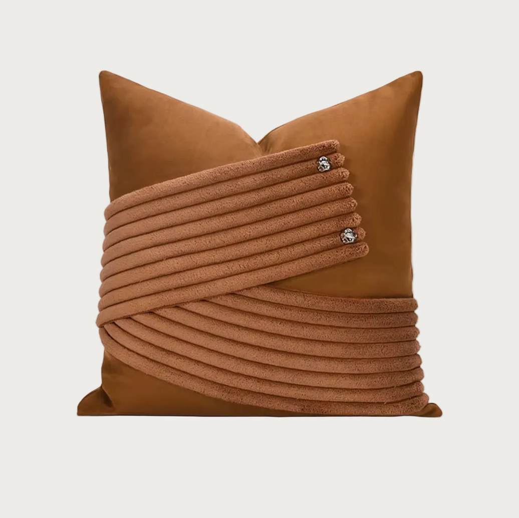 A square brown throw pillow featuring a textured, ribbed wrap design across the front with three small silver decorative studs, shown on a plain white background.