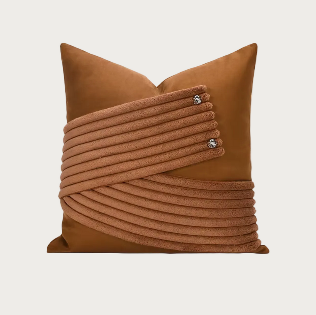 A square brown throw pillow featuring a textured, ribbed wrap design across the front with three small silver decorative studs, shown on a plain white background.