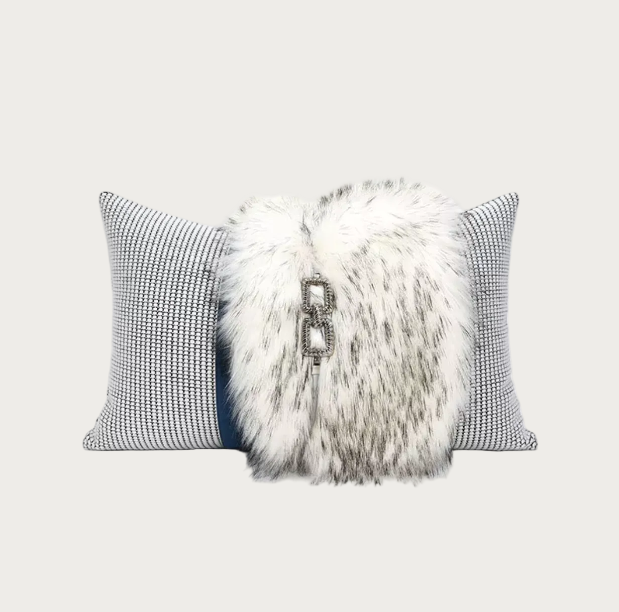 A decorative throw pillow set featuring a central white and gray faux fur pillow with a silver-tone metal clasp, flanked by two gray and white patterned pillows on a white background.