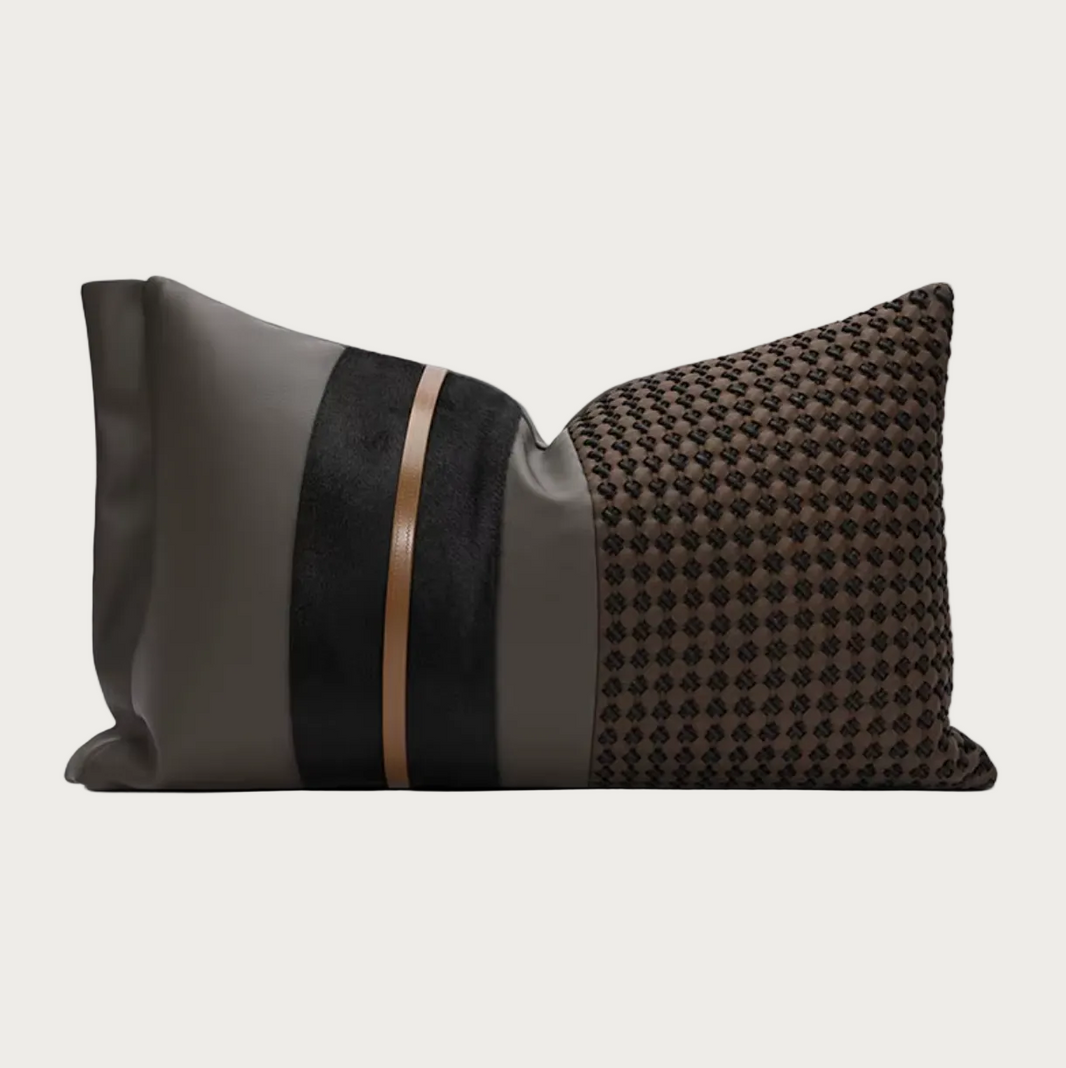A modern decorative throw pillow featuring a tri-color design: a smooth dark gray panel on the left, a vertical black velvet stripe with a thin metallic bronze accent in the middle, and a textured black-and-brown houndstooth pattern on the right, shown on a plain white background.
