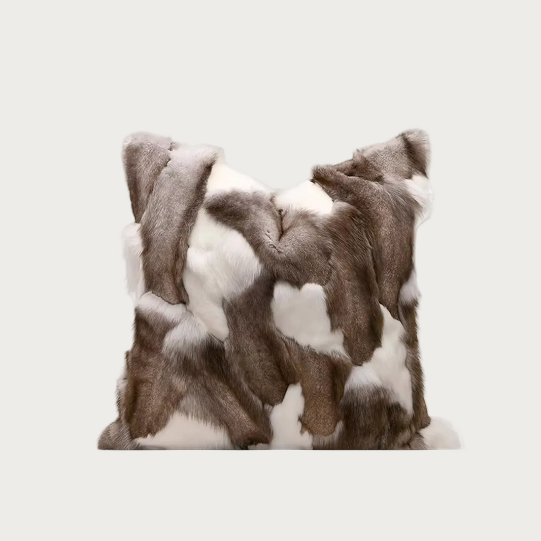 A square faux fur throw pillow with a brown and white  print pattern, shown against a plain white background.