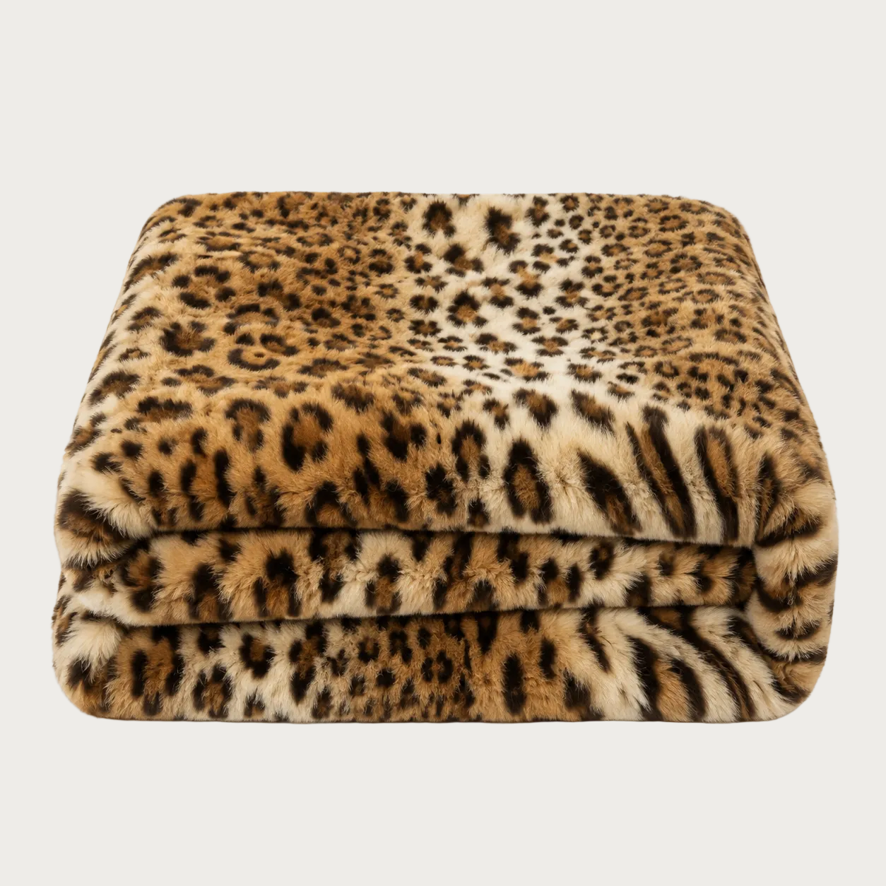 A folded plush throw blanket featuring a leopard print pattern in shades of brown, beige, and black, set against a plain white background.